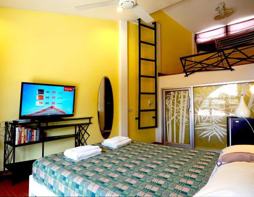 a bedroom with a bed and a tv and a room at Phuket Paradiso in Chalong 