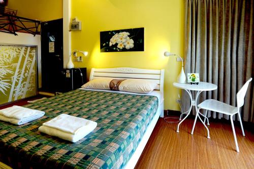 a bedroom with a bed and a table in it at Phuket Paradiso in Chalong 
