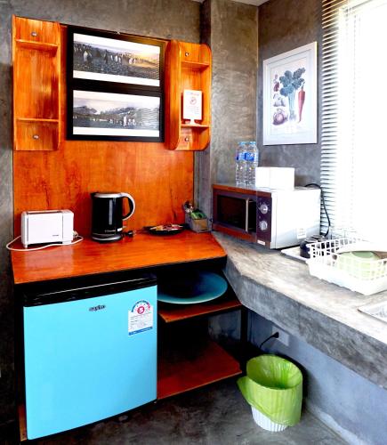 a kitchen with a counter with a refrigerator and a microwave at Phuket Paradiso in Chalong 
