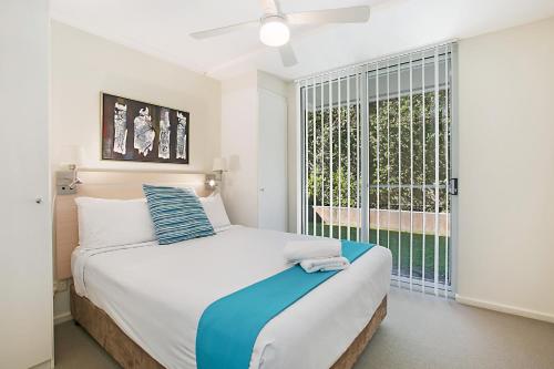 a bedroom with a bed and a large window at Mantra Nelson Bay in Nelson Bay