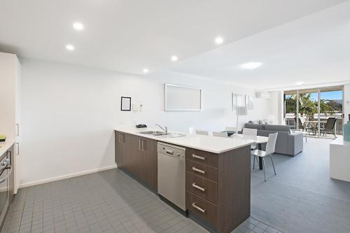 a kitchen with a counter and a dining room at Mantra Nelson Bay in Nelson Bay
