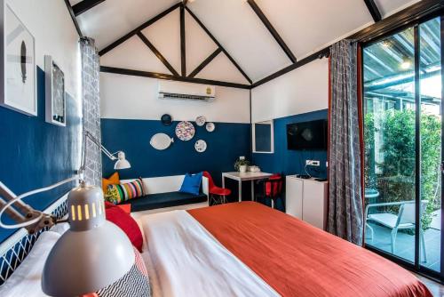 a bedroom with a bed and a room with a window at Villa Na Pran, Pool Villa in Pran Buri