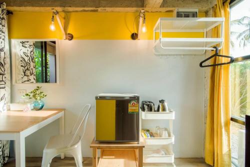 a small kitchen with a table and a yellow wall at Villa Na Pran, Pool Villa in Pran Buri