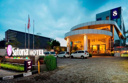 un hotel con coches estacionados frente a un edificio en Satoria Hotel Yogyakarta - CHSE Certified, en Yogyakarta