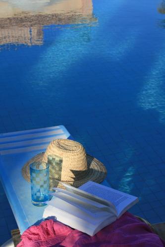 a hat and a book and a glass of water at Casa Taos in Marrakech