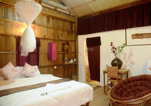 a bedroom with a bed and a chair at Fish Island Bungalows in Kampot