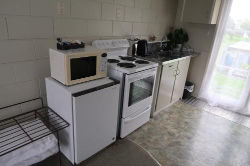 a kitchen with a microwave and a stove top oven at North End Motel in Huntly