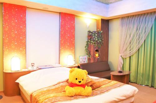 een gele teddybeer op een bed bij Hotel Pal Furugou (Love Hotel) in Oita
