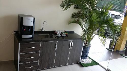 una cucina con lavandino e macchina da caffè di Mass Hotel a Kampong Kerayong