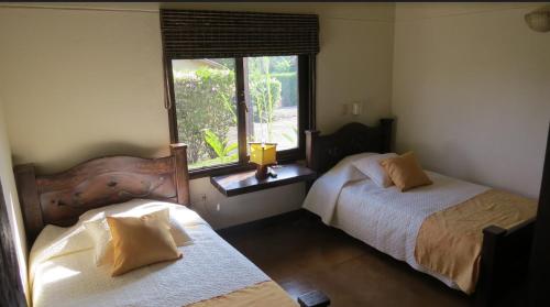 1 dormitorio con 2 camas y ventana en Fincas Panaca Herreria 26, en Quimbaya