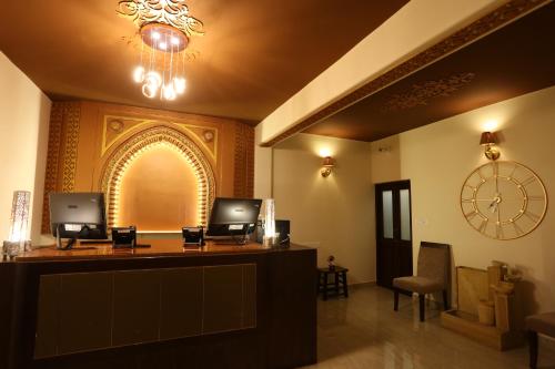 a hotel reception desk with a clock on the wall at Sinon Baga Retreat in Baga