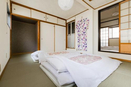 two beds in a room with two windows at Yukiya in Osaka