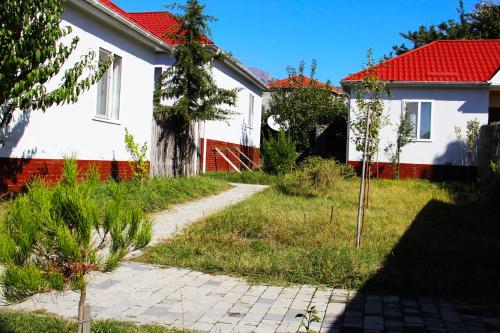 a house with a tree next to a walkway at Gabala Homes Musa in Gabala