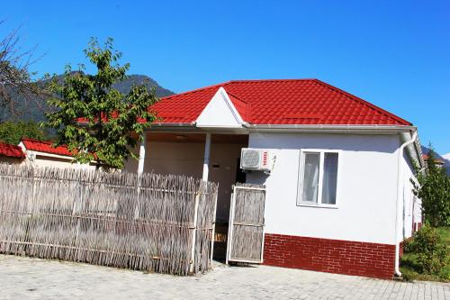 a white house with a red roof and a fence at Gabala Homes Musa in Gabala