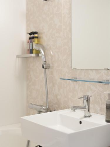 a bathroom with a white sink and a mirror at Hotel Wing International Hakata Shinkansenguchi in Fukuoka
