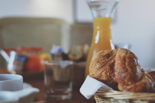 a table with a basket of bread and a bottle of orange juice at Hôtel de France in Saint-Savin-sur-Gartempe