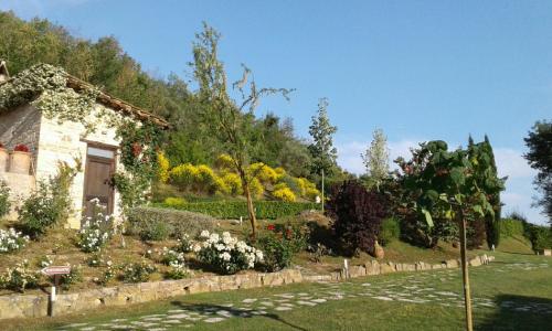 a garden with a stone house and flowers at Hotel & SPA L'Antico Forziere in Deruta