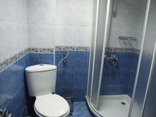 a blue tiled bathroom with a toilet and a shower at Guest House Zlatev in Bansko