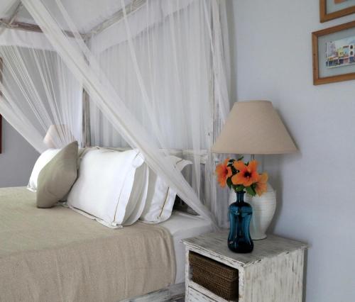 a bedroom with a bed and a vase with flowers on a table at Bungalow Sud in Habaraduwa Central