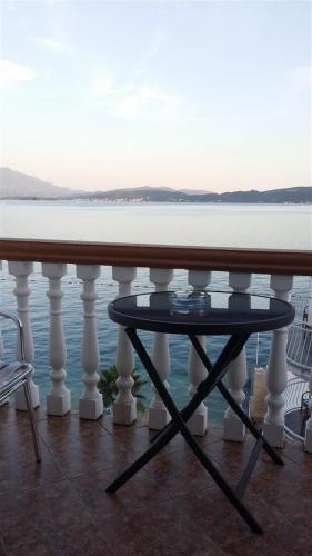 a table on a balcony with a view of the water at Apartmani Kalinic in Bijela