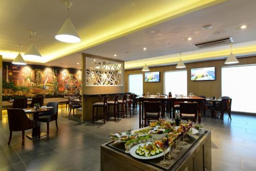 a restaurant with plates of food on a buffet at Howard Johnson by Wyndham, Kolkata Airport in Kolkata