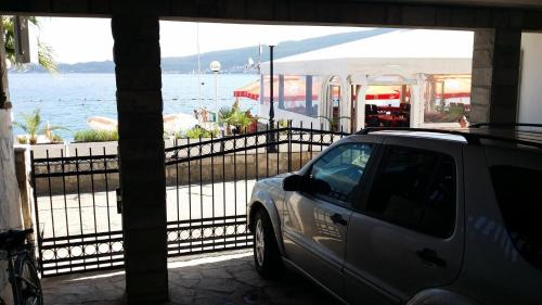 a car parked outside a building with a view of the water at Apartmani Kalinic in Bijela