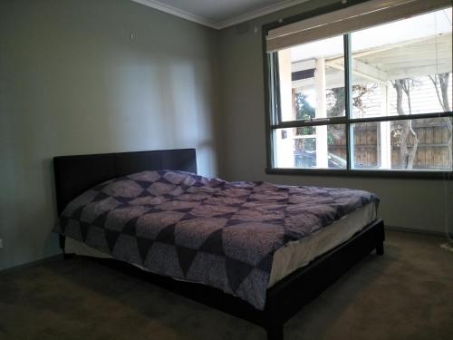 a bedroom with a bed and a window at 6 Bedrooms/9 Beds Huge House|City+Park Views|Beach in Frankston