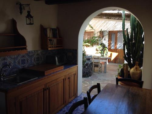 斯特龍博利的住宿－La Lampara，厨房设有拱门、桌子和用餐室。
