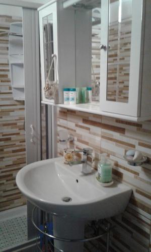 y baño con lavabo blanco y espejo. en Casa Da Peppe, en Catania