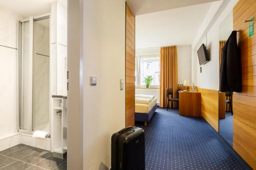 a hotel room with a bed and a bathroom at MesseHotel Köln-Deutz in Cologne