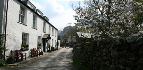 a street with a stone wall next to a building at The Langstrath Country Inn in Keswick