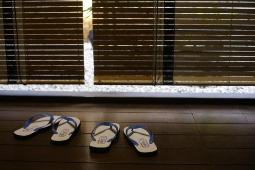 two pairs of sandals sitting next to a window at Tian Jing Hotel in Kuala Lumpur