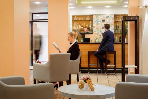 a woman sitting at the counter of a bar at MesseHotel Köln-Deutz in Cologne