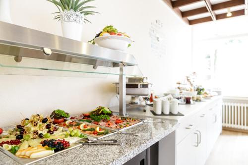 a kitchen with many plates of food on a counter at MesseHotel Köln-Deutz in Cologne