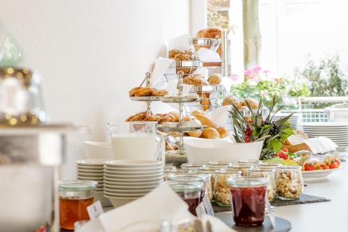 a table topped with plates and pastries and desserts at MesseHotel Köln-Deutz in Cologne