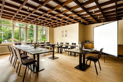 a restaurant with tables and chairs and large windows at MesseHotel Köln-Deutz in Cologne