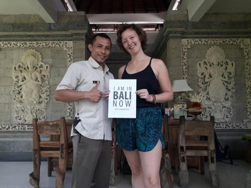 a man and a woman holding a sign saying new ball no way at Om Ham Retreat and Resort in Ubud