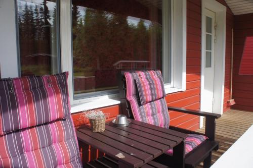 a wooden table and two chairs on a porch at Motelli Rovaniemi in Rovaniemi