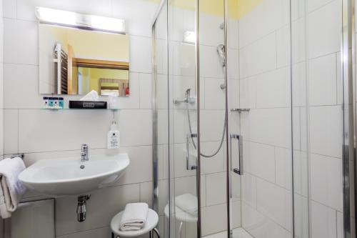 a bathroom with a shower and a sink and a toilet at Hotel Kasserolle in Siegburg