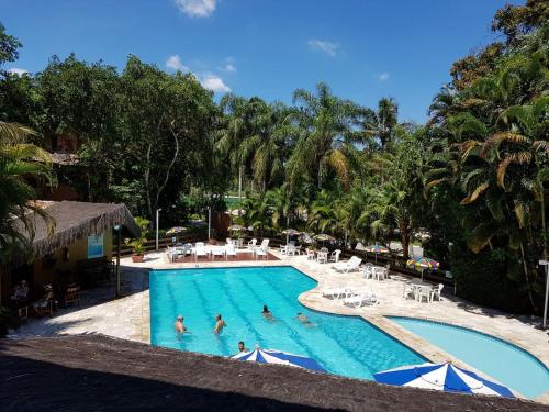 a large swimming pool with people in the water at Flat 102 in Riviera de São Lourenço