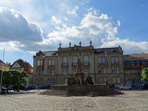a large building with a statue in front of it at Grunau Hotel in Bayreuth