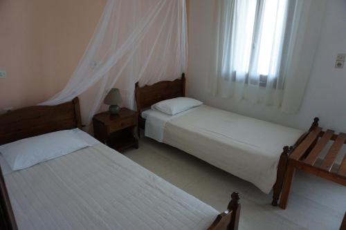 a bedroom with two beds and a window at Studios Andreas in Boukari