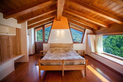 ein Schlafzimmer mit einem Bett in einem Zimmer mit Fenstern in der Unterkunft Casa Panoramica in Aosta