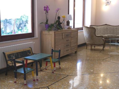 a room with chairs and a dresser and a table at Hotel Flora in Celle Ligure