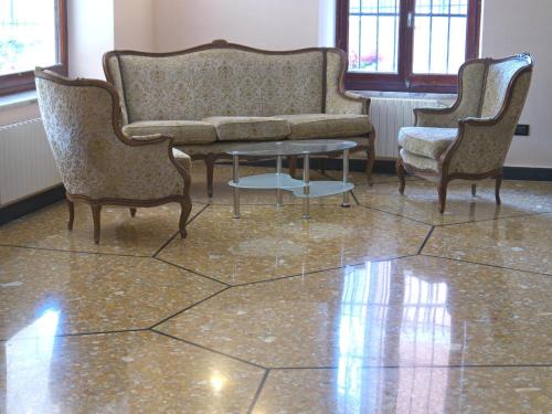 a couch and two chairs and a table in a room at Hotel Flora in Celle Ligure
