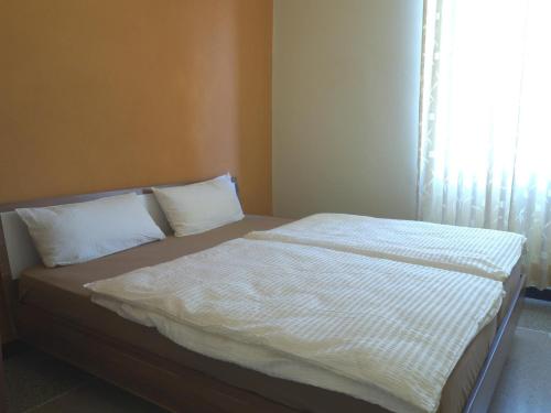a bed with white sheets and pillows in a bedroom at Hotel Flora in Celle Ligure