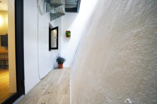 a hallway with a white wall and a wooden floor at The Red Hotel in Nanwan