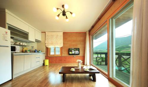 a kitchen with a table and a large window at Daegwanryeong Rodem Tree Pension in Pyeongchang 