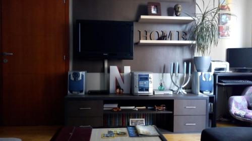 ein Wohnzimmer mit einem TV auf dem Tisch in der Unterkunft Naissa Apartment in Niš