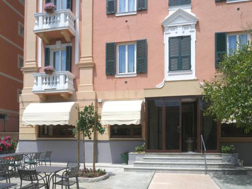 a building with tables and chairs in front of it at Hotel Flora in Celle Ligure